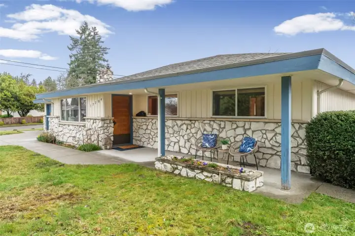 Covered front porch with stone detailing and sturdy columns offers a comfortable place to sit and enjoy the neighborhood. Large front windows and a warm wood entry door add character and visual interest.