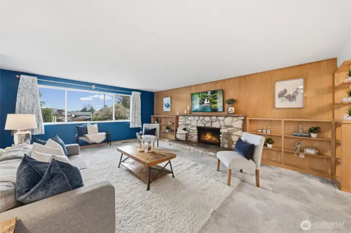 Large picture window fills the living area with natural light while offering views of the neighborhood. The open layout easily connects to the adjacent dining area, creating a comfortable flow for gatherings and everyday living.