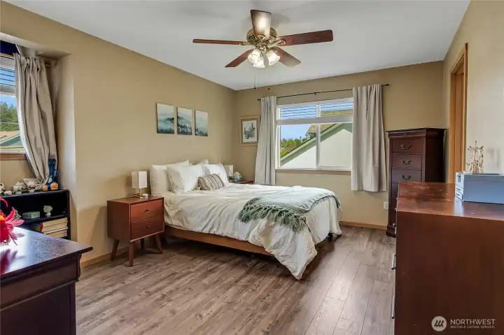 Primary bedroom with ceiling fan and laminate flooring.
