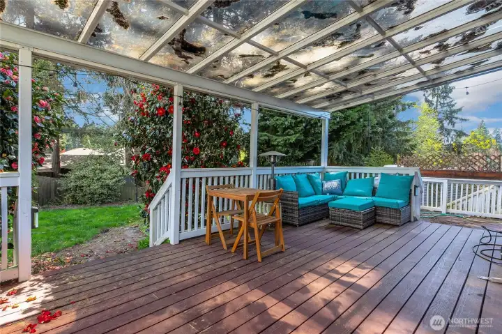 Covered deck spanning rear of home with multi-level layout and overhead cover.
