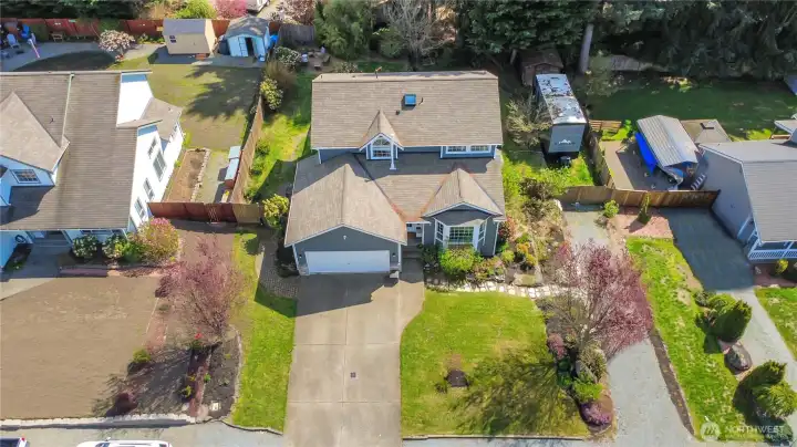 Aerial view showing extended driveway, additional side parking, and fenced area with RV parking potential.