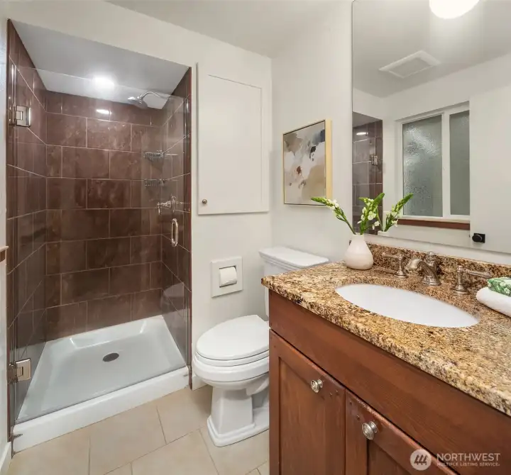 Primary en-suite with counter to ceiling mirror.