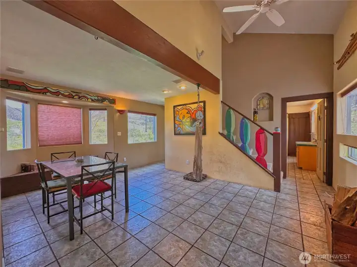 Vaulted ceilings with exposed wood beams and multiple bay window bench seating areas, enhance this gathering space