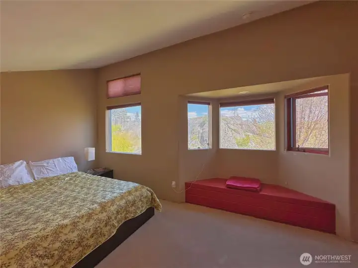Large primary bedroom with vaulted ceiling, bay window bench seating & walk in closet