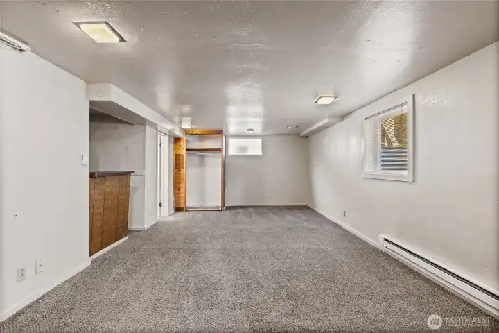 The basement is half finished with this finished family room on one side and the unfinished mechanical and storage area on the other side. There is an independent door for ingress and egress making this an excellent opportunity as a 5th bedroom, a family room, or a rentable space. The nook to the left of the photo is a small kitchenette space, best for a microwave or smart oven. The basement is half finished with this finished family room on one side and the unfinished mechanical and storage area on the other side. There is an independent door for ingress and egress making this an excellent opportunity as a 5th bedroom, a family room, or a rentable space. The nook to the left of the photo is a small kitchenette space, best for a microwave or smart oven.