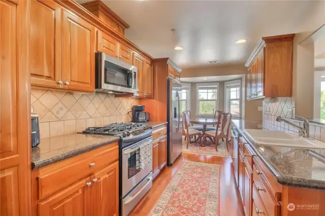 Full backsplash, SS appliances, wood floors, quartz countertops - elegant!