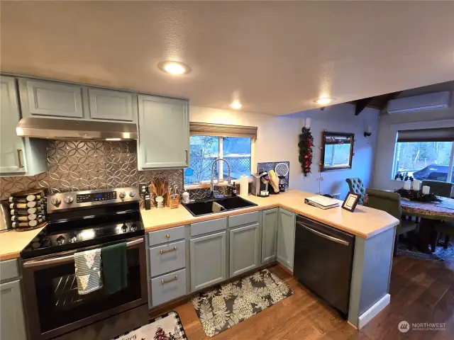 Nicely appointed kitchen has a good amount of counter space and an L-shaped eating bar with stools on the back side.