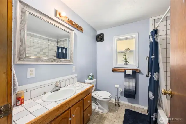 Full bathroom located on main floor with tile flooring and tile surround tub/shower.