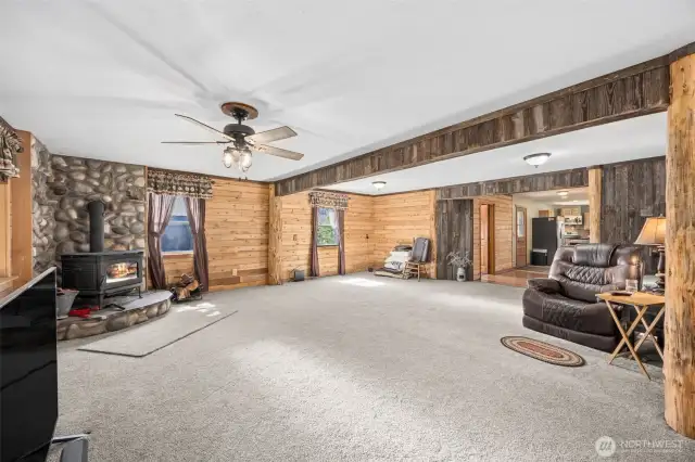 River rock fireplace surrounds the free standing stove in the large family room. Located just between the front door & side porch door that opens into the kitchen.