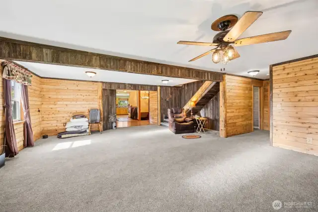 From this angle you can see to the right down the short hallway are two bedrooms + bathroom. Stairs lead upstairs to an office + extra finished room could be a play room! And just beside the kitchen in this photo is the staircase that leads to the lower level bonus room.