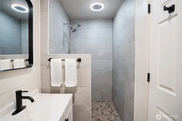 The main bathroom features a large, walk-in shower with bluetooth speaker.