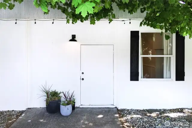 Home features two entry options -- this Lake side entrance offers a large door shaded by mature trees.
