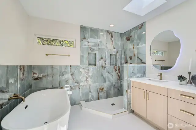 Luxurious primary bath with skylight, standalone tub, and separate shower.