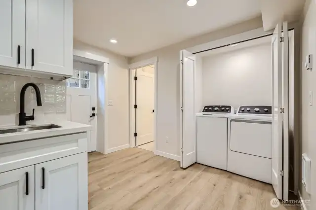 Lower level is an excellent potential for a mother-in-law suite, complete with a kitchenette, two bedrooms, a full bath, a laundry area, and a private entrance.