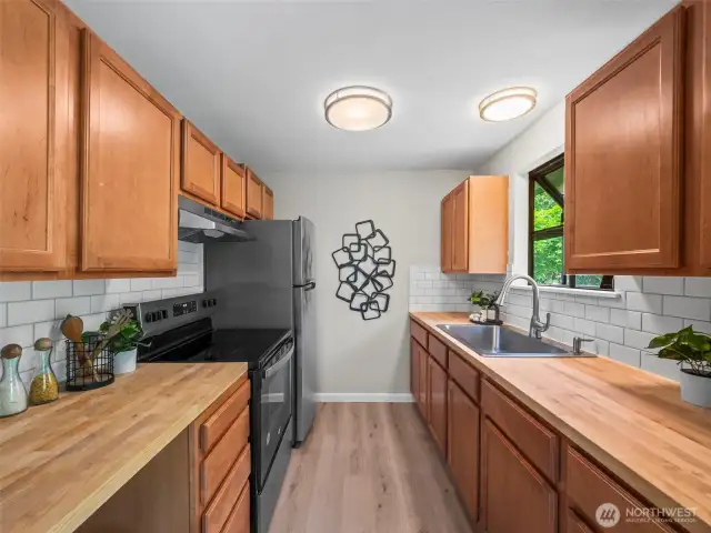 The kitchen has been updated with new cabinets and counters as well as apppliances. The natural wood tones play well overall in the spaces this home creates.