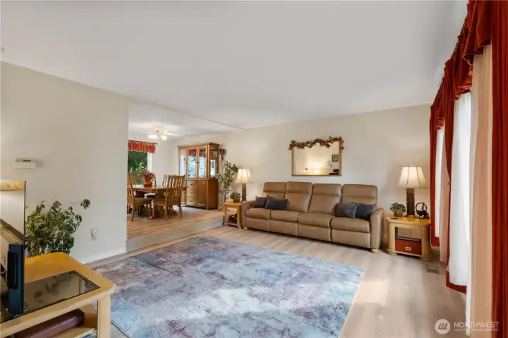 Step into a spacious living room where there's an abundance of natural light from the windows and the newer vinyl plank flooring (replaced 2024) adds both style and durability.