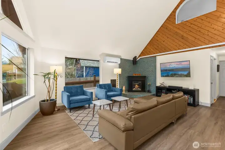 Living room with updated Luxury Vinyl Plank flooring, new tiled fireplace corner complete with electric fireplace. LARGE amounts of natural light from all the windows.