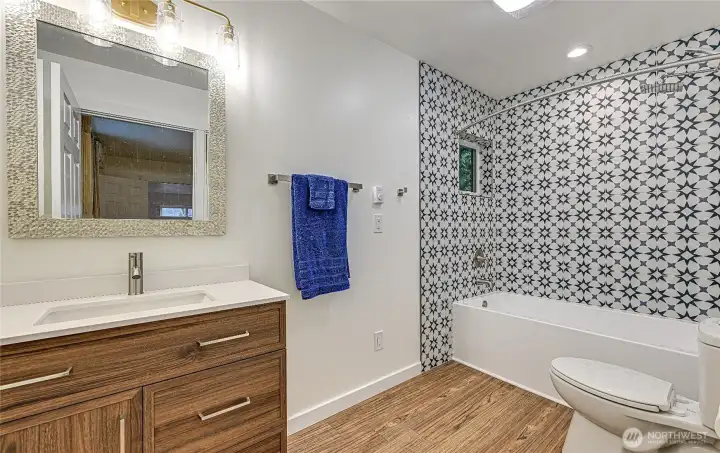 Full bathroom off bedroom of the DADU apartment above garage/shop. Features tiled shower walls, Luxury Vinyl Plank flooring, modern vanity with inset sink.