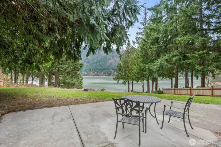 Back patio with the framed overlook of Alder Lake through the evergreens.