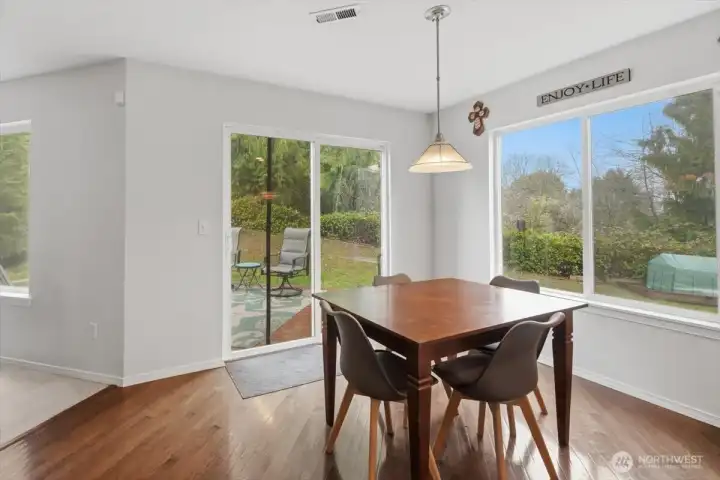 Casual dining area with access to the oversized back deck featuring peaceful and serene views of the green space behind the home.