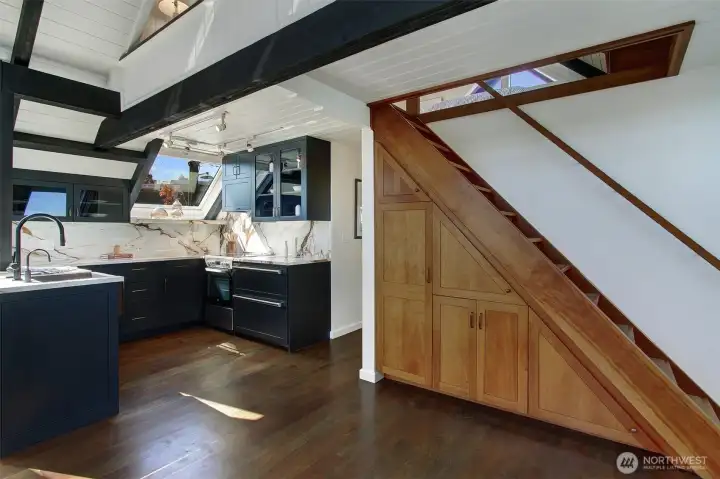The staircase is thoughtfully positioned so that it is not obstructing the flow of the open living/dining area.  Super under stairs storage is like your pantry or more closet space.