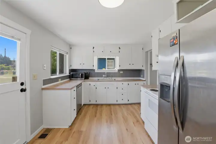 Functional kitchen — White cabinetry, stainless steel appliances, and tons of natural light.
