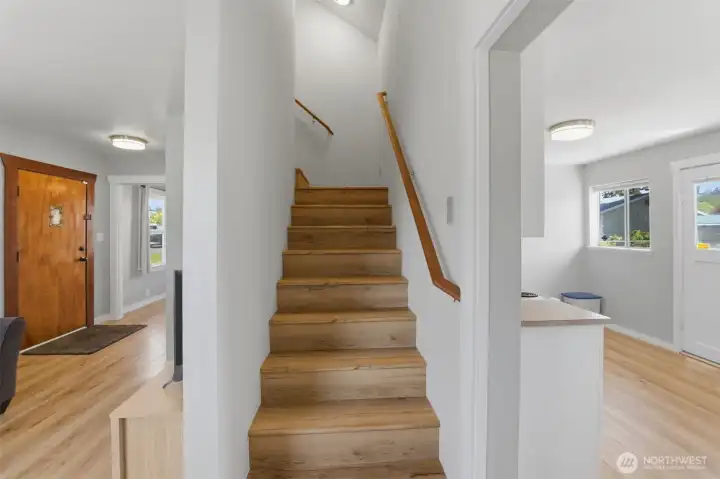 Hardwood staircase — Warm wood stairs lead to the upper-level bedrooms; classic original front door adds character.