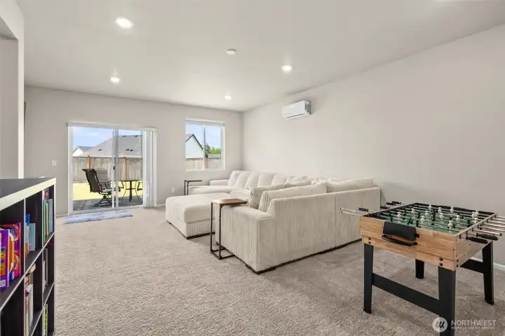 Downstairs gathering space leads into the large fenced backyard