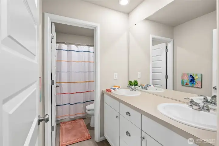 Upstairs hall bath features dual vanity for easy sharing