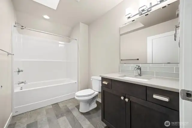 There is a full bath upstairs with the same tile backsplash as the kitchen and the other bathroom has.