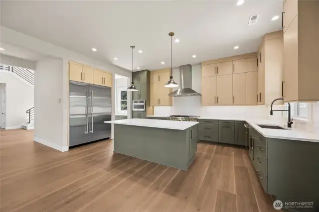 Striking modern kitchen featuring a two-tone design with rich olive base cabinets and sleek natural wood uppers, complemented by quartz countertops, stainless steel appliances, and a spacious center island with pendant lighting—perfect for entertaining and everyday living.
