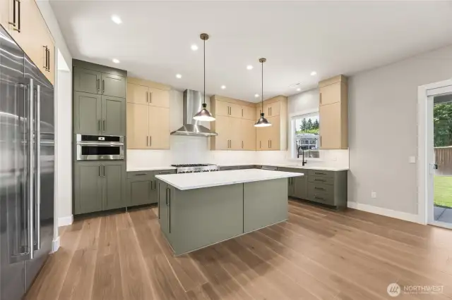 Stylish and functional, this kitchen features designer two-tone cabinets, sleek pendant lighting, and a spacious island with quartz countertops. Premium stainless appliances, ample prep space, and backyard views make it the heart of the home.