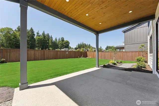 Spacious covered patio with tongue-and-groove ceiling, recessed lighting, and a beautifully landscaped, fully fenced backyard—perfect for year-round outdoor living.