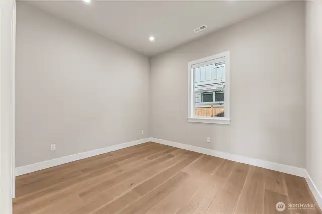 Private main-floor bedroom with LVP flooring and a full bath nearby—ideal for guests, a home office, or flexible living.