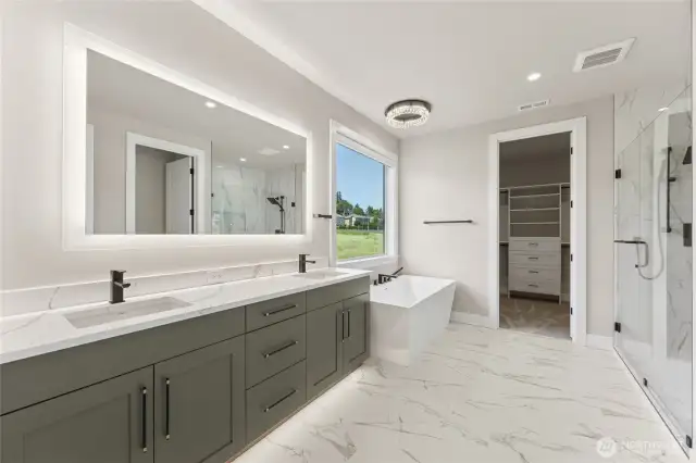 Spa-inspired primary bath with dual sinks, quartz counters, LED mirror, a soaking tub with scenic views, and a large walk-in shower with frameless glass.