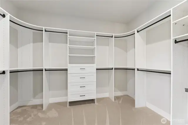The spacious walk-in closet offers built-in shelving, drawers, and multiple hanging areas, providing both function and flexibility for organized storage.