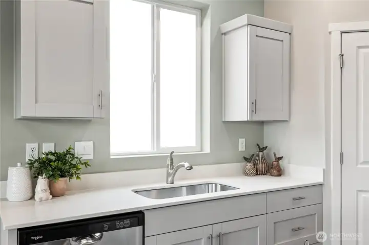 Deep butcher style stainless steel sink and dishwasher makes dishes a breeze. Photo is representational. Actual home is under construction. Colors, materials, and features may vary. See site agent for details.