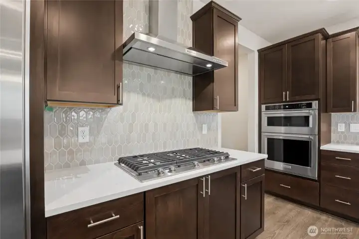 Upgraded appliances with gas cooktop and separate range hood, built-in wall oven and microwave.  Actual home is under construction and materials, colors, and finishes will vary. See site agent for details.