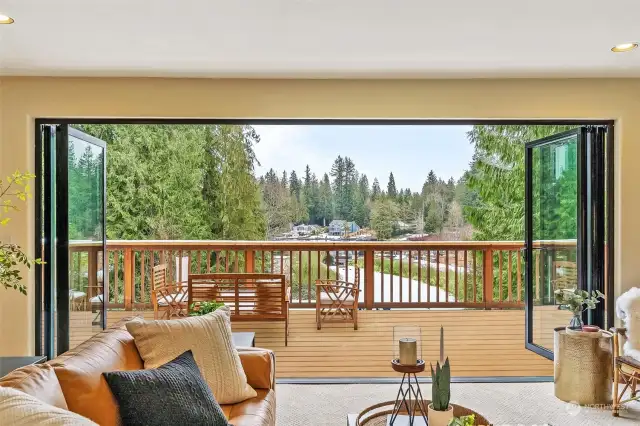 Seamless Indoor-Outdoor Living. The NanaWall glass doors fully retract, opening the living space to the expansive deck for effortless entertaining.