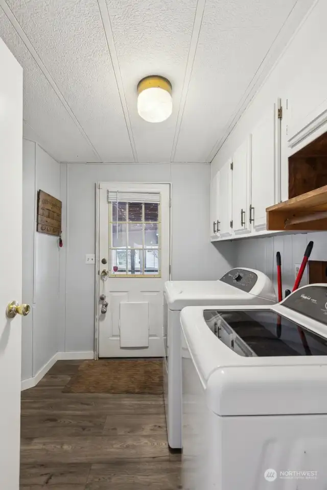 Utility room has extra storage around the corner. Washer and dryer stay! This door leads to the covered deck and carport.