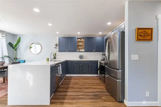 A beautifully updated kitchen with navy cabinets and quartz countertops.