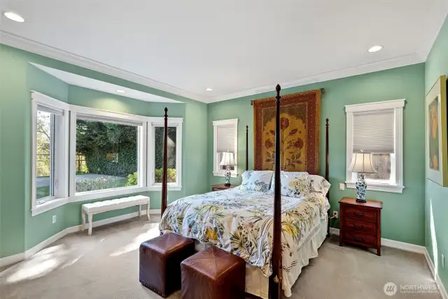 Main floor primary bedroom with bay window overlooking the back yard