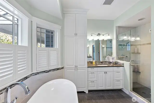 Primary bathroom features two separate vanities and a walk-in shower