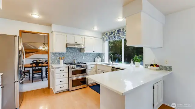 The beautifully updated kitchen has hardwood floors, gleaming quartz counters with glass tile backsplash.  There is a 3-spot eat bar that is wonderful for being near the chef.