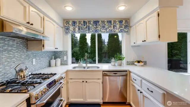 There is gas cooking with a double oven and cooktop with a powerful vent above.