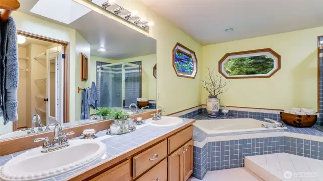 The primary bath is a 5-piece bath with 2 sinks, soaking tub, separate shower and walk-in closet. area.  The counter is tile along with the flooring and the bath and shower surround.