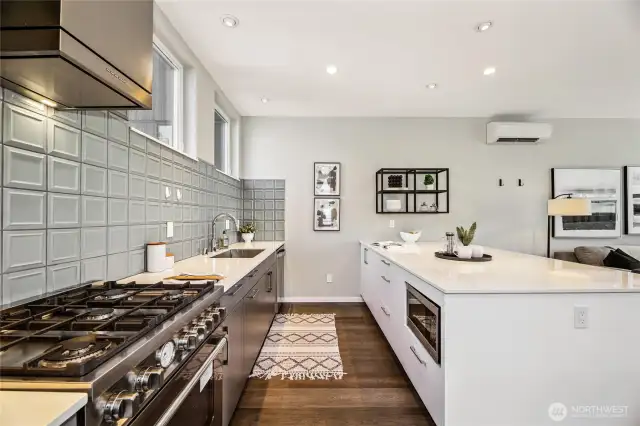 Sleek backsplash, microwave, quartz countertops. This is how it should be.