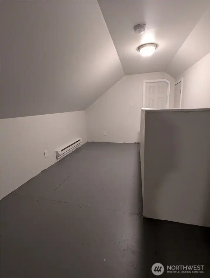 The space between upstairs bedrooms has space for a couch. There is a storage room at the top of the stairs.