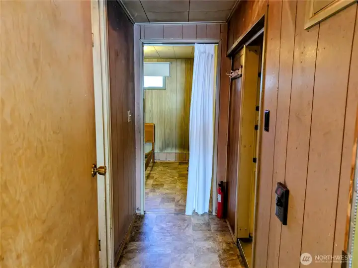 Hall from main bedroom into the house kitchen to the right, bathroom to the left
