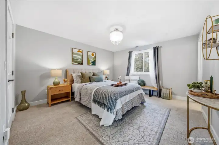 Spacious primary bedroom overlooking backyard.